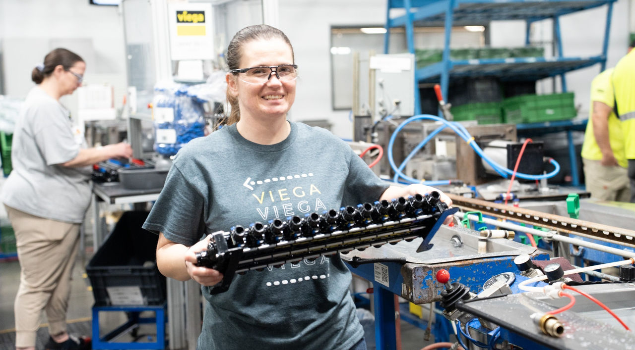 Worker holding industrial pipe assembly