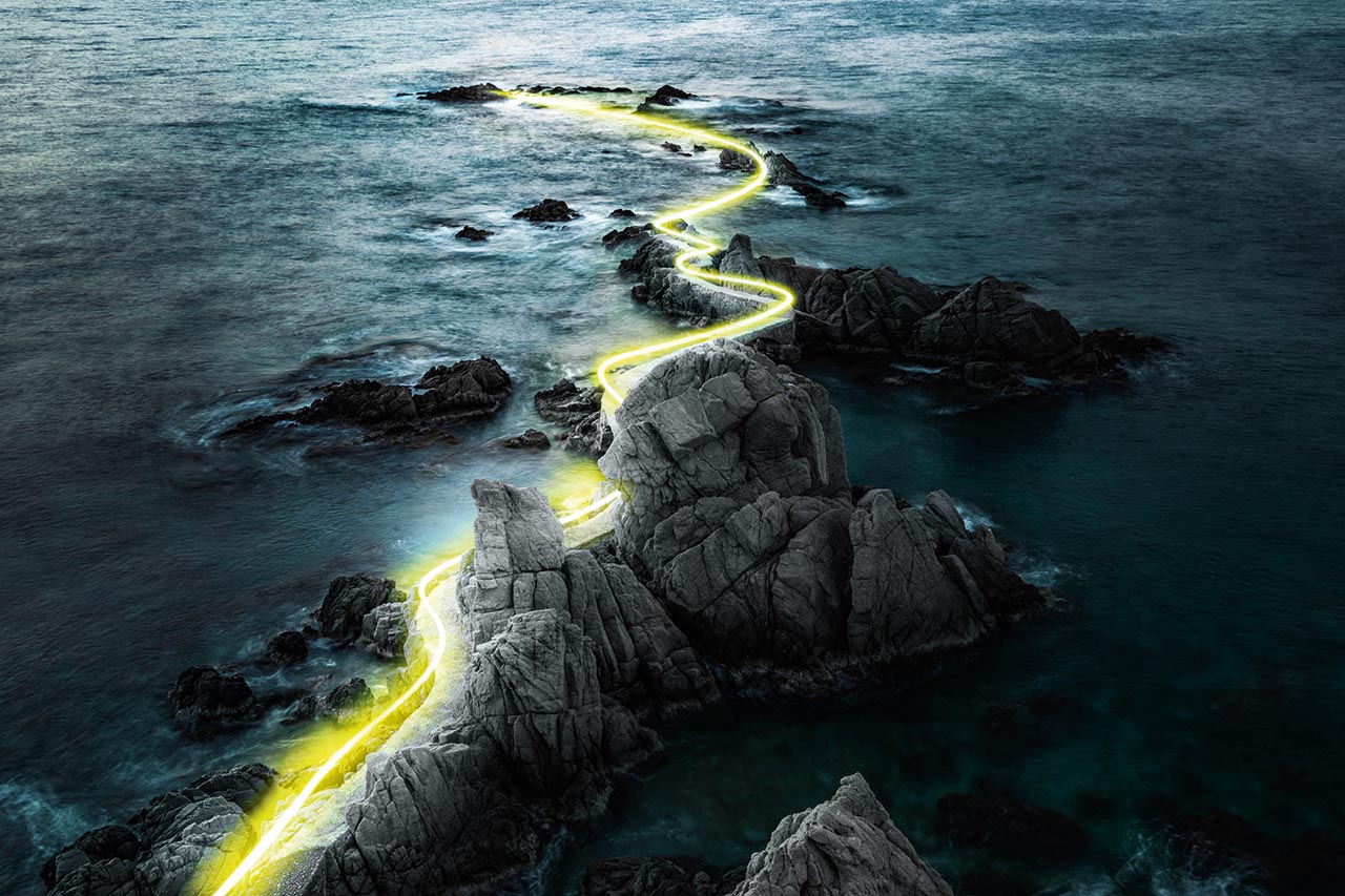Yellow light painting through a rock formation of Costa Brava coastline, leading into the ocean. Stock-ID 1149030626