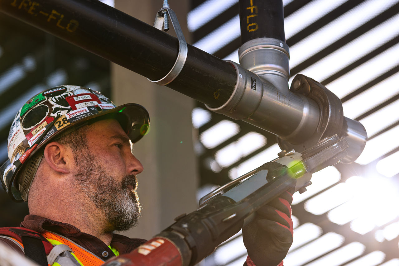 Man using pressgun to install MegaPress