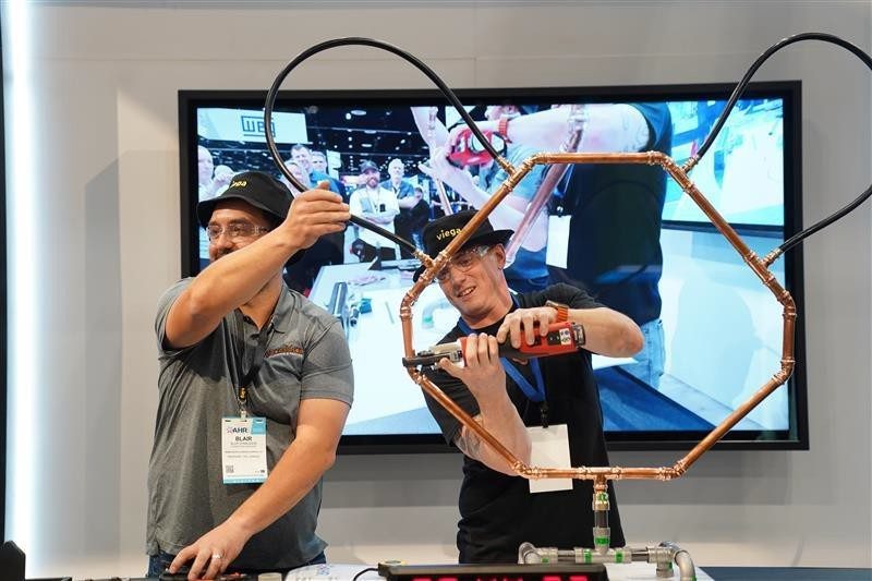 People making a mouse shape with Viega connectors at AHR